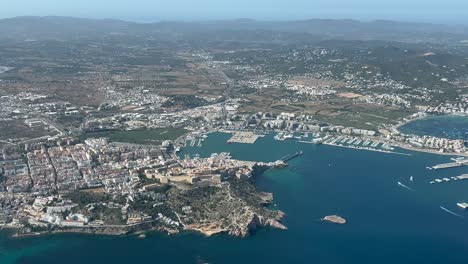 Aerial-view-of-Ibiza-city-and-harbor,-shot-from-an-airplane-in-a-splendid-summer-day