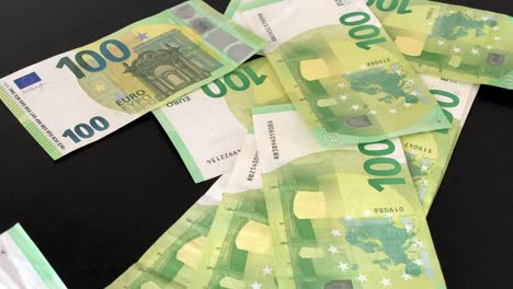 green 100 euros drop on table