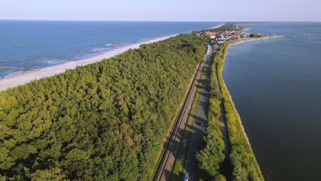 cine aéreo hermoso camino recto a lo largo del bosque entre la bahía y las aguas del mar, kuznica polonia