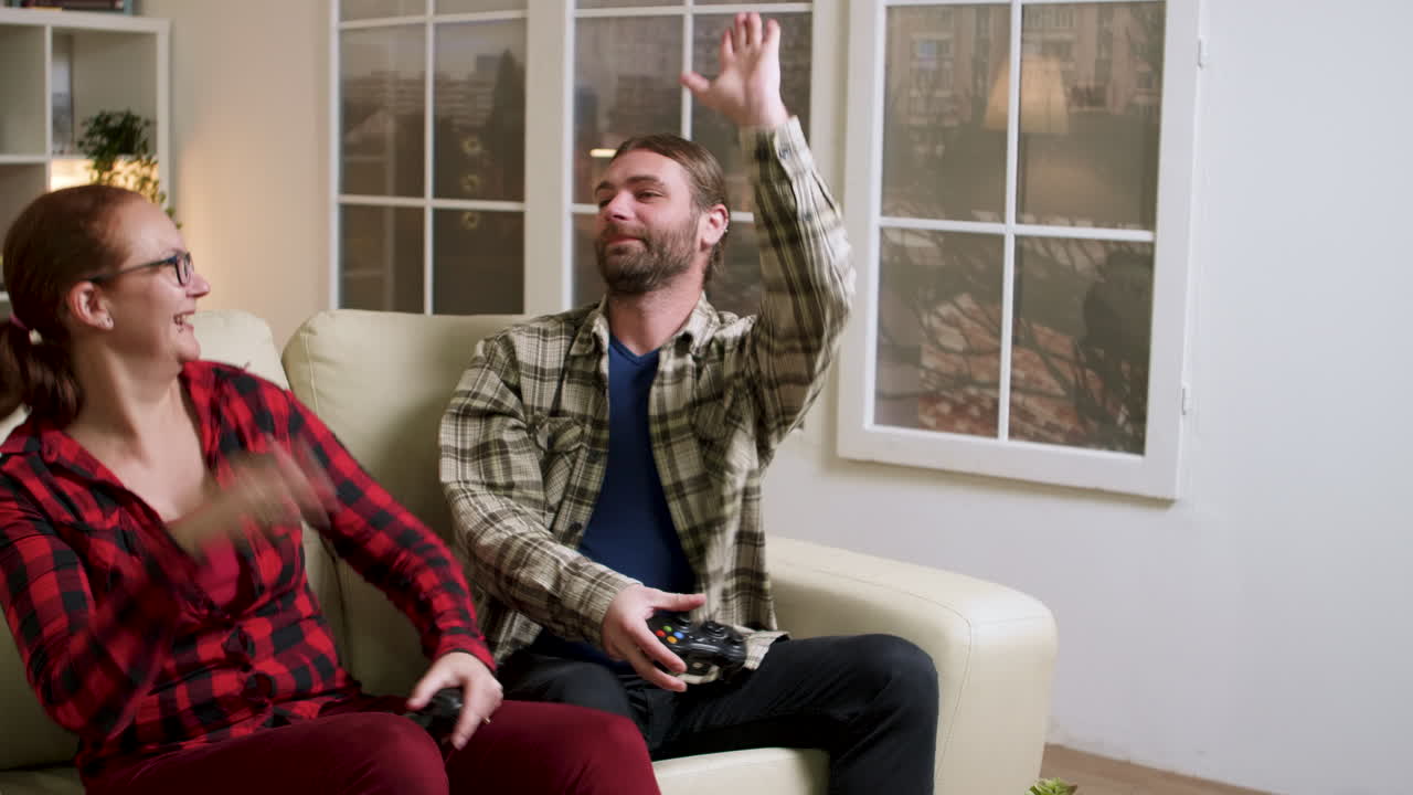 부부가 소파에서 비디오 게임을 하고 있다