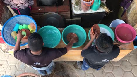 men washing pottery and dishes outdoors