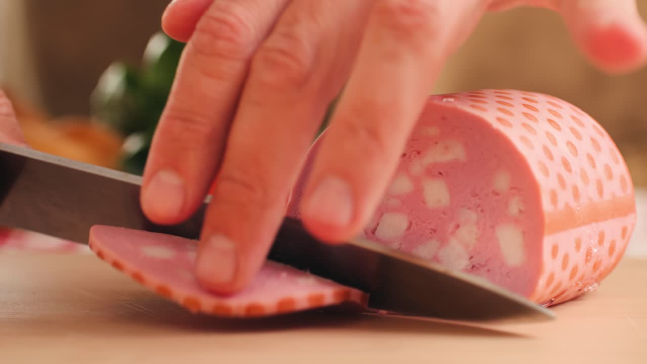 Ham italian mordatella, man Slices Of Traditional Italian antipasti mortadella sausage on a wooden cutting board, close up macro of chicken or turkey jamon, fat breakfast dish.