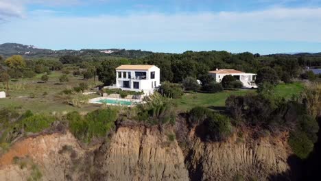 perfecto vuelo aéreo de drones volar hacia atrás toma de drones de una casa solitaria en un alto acantilado y cañón