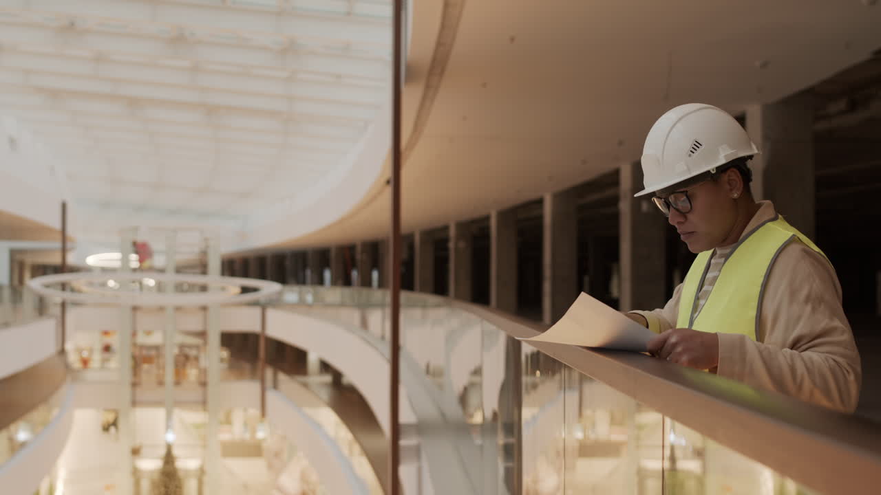 trabajador de la construcción comprobando papeles en el centro comercial