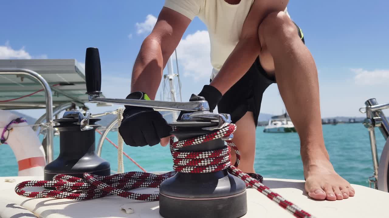 persona que opera cabrestantes en un yate de vela