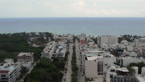 an aerial shot pushing into the coastline from the city of playa del carmen in mexico on an overcast day
