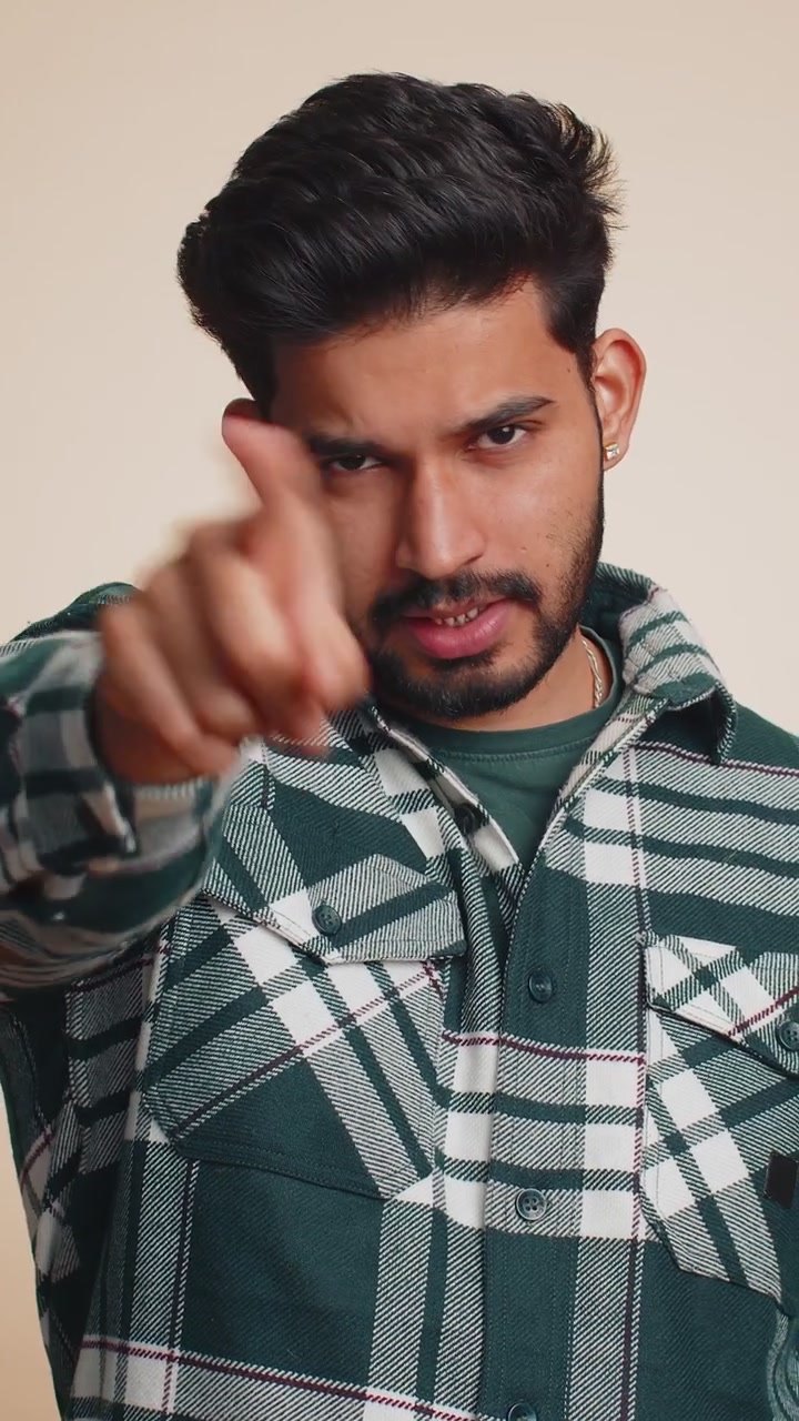 Indian man smiling excitedly pointing to camera choosing lucky happy winner indicating hey you