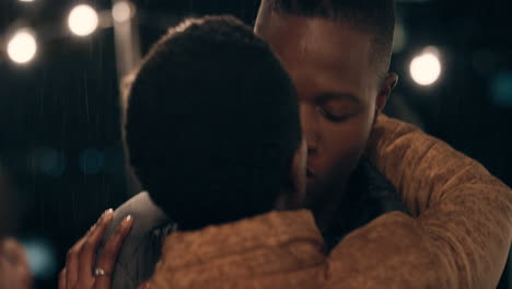 happy-african-american-couple-kissing-having-fun-dancing-in-rain-enjoying-lively-rooftop-party-celebration-at-night