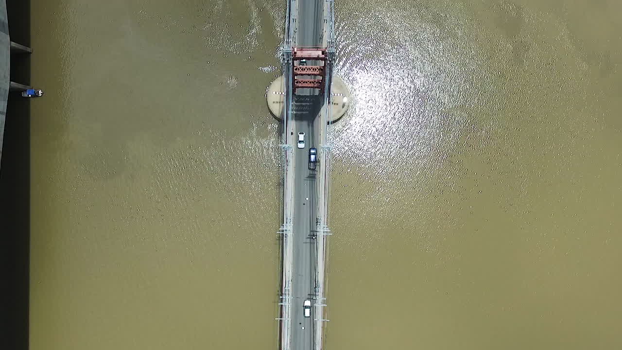 진흙 투성이의 강물 위의 현수교에서 교통의 높은 각도의 조감도