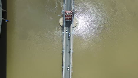 vista aérea de alto ángulo del tráfico en el puente colgante sobre el agua del río fangoso