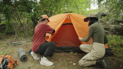 Asian Women Setting Up Tent for Camping in Woods