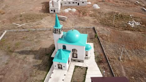 aerial: small mosque is shining in sunrise.