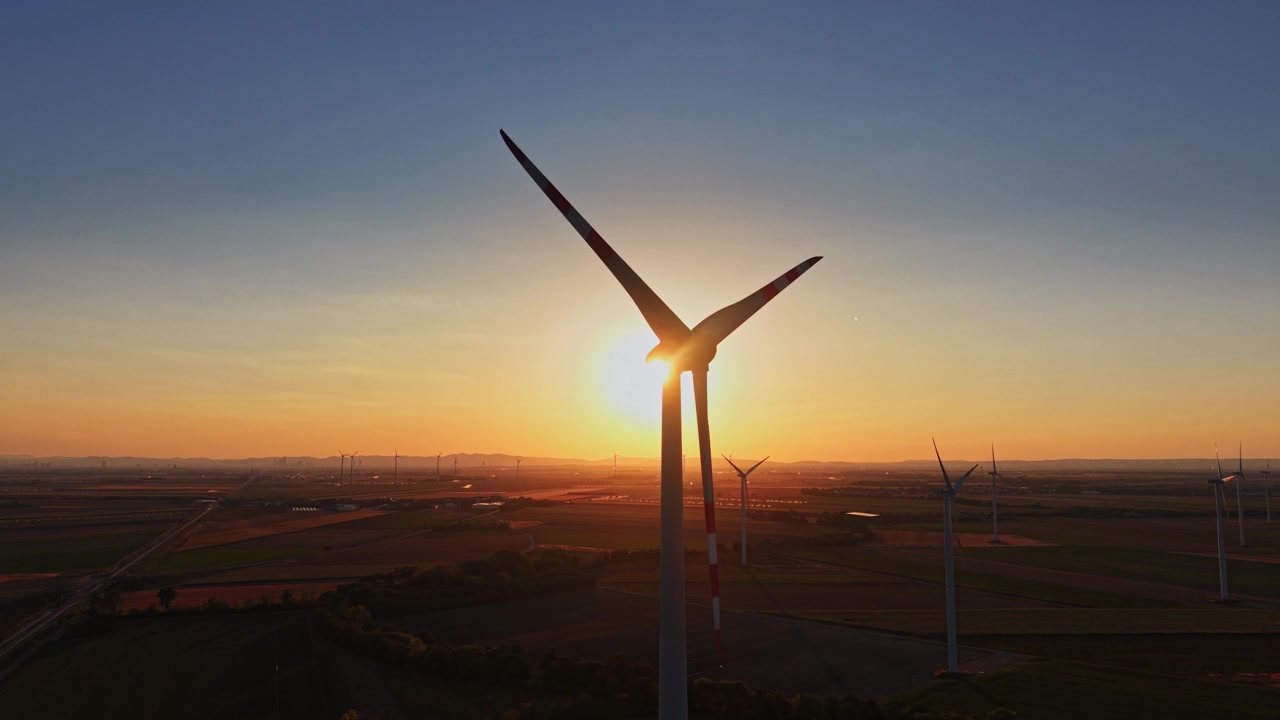 Vindturbiner ved solnedgang på et vidt åpent jorde.