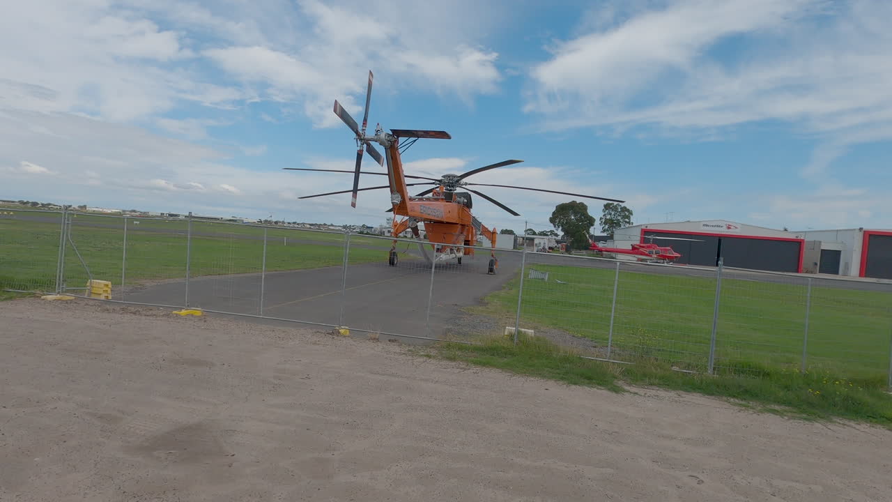 Erickson  air crane helicopter parked at an airport ready to fight fires.