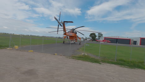 erickson  air crane helicopter parked at an airport ready to fight fires.