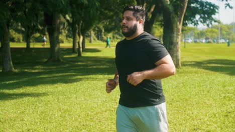 Young-man-jogging-at-the-park-on-a-sunny-summer-day