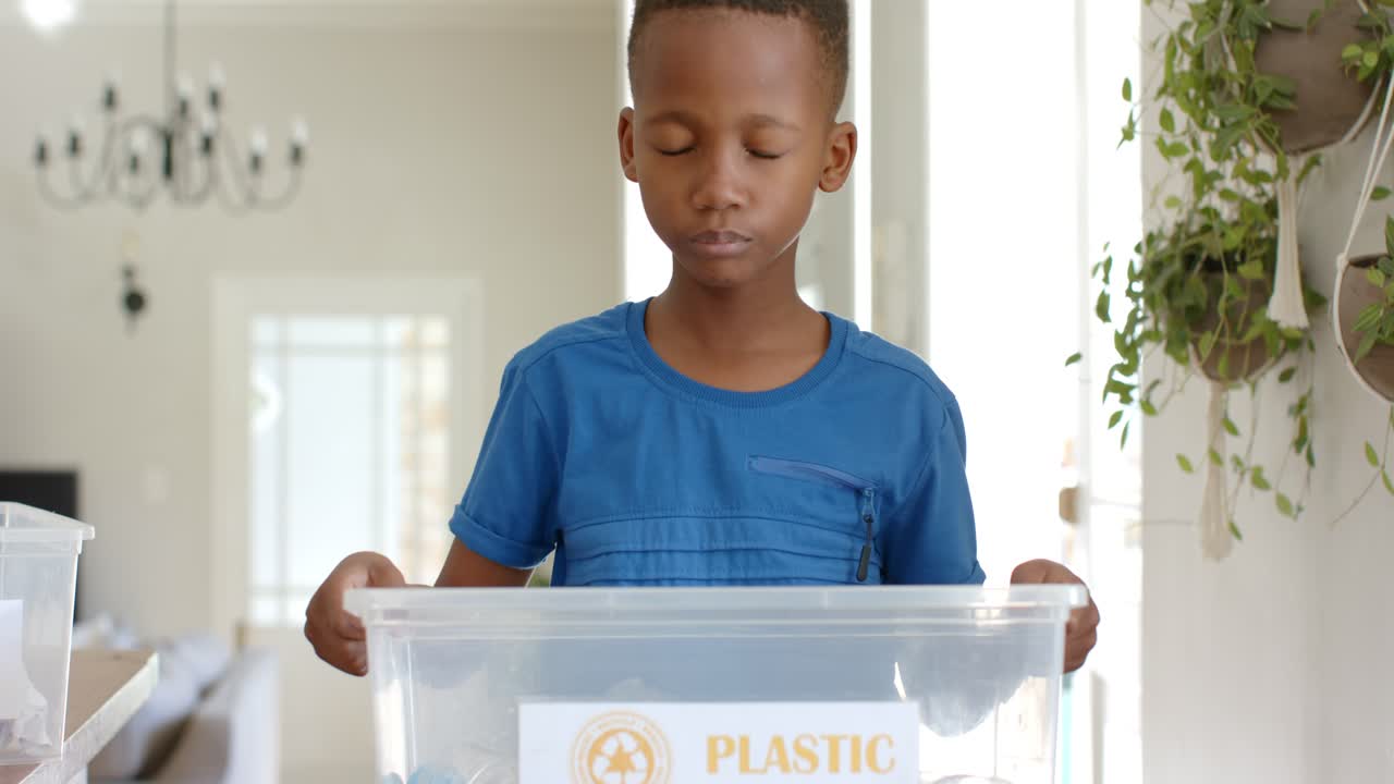 Reaching from right, African American boy child lifting PLASTIC bin, checking items in dining room