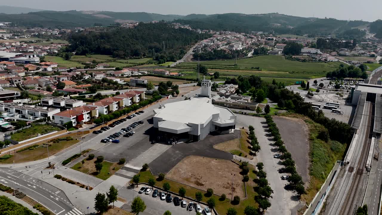 포르투갈 트로파에 있는 현대적인 흰색 교회와 주변 마을의 드론 뷰