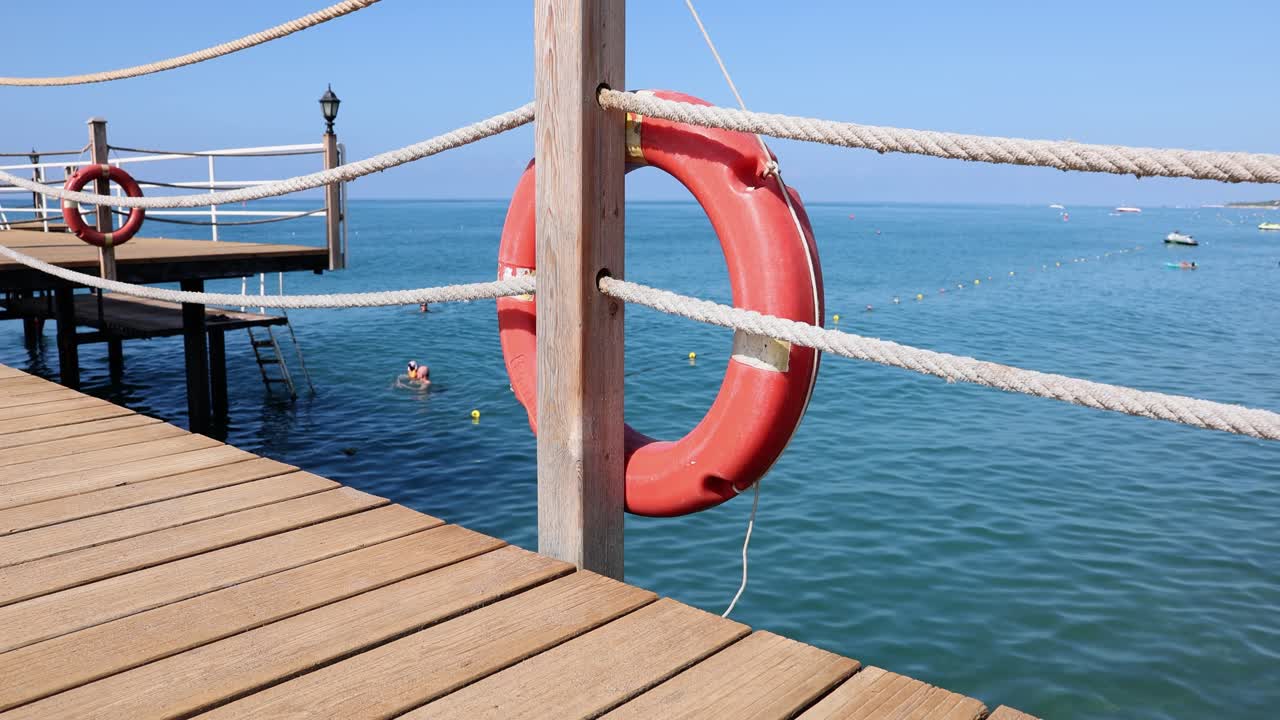 A view of a pier with a lifebuoy on a sunny day