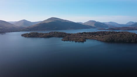 pan round loch lomond water and view over islands to ben lomond mountain on a sunny day