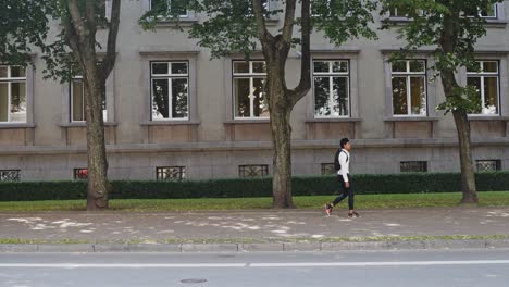 Confident-classy-man-with-white-shirt-and-backpack-walking-on-sidewalk