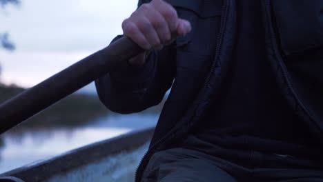 fisherman rowing boat close up on wooden oars