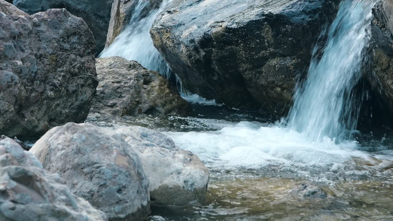 Piccola cascata che scorre su grandi rocce in un ruscello limpido vicino a Weesen, San Gallo, Svizzera, Walensee.