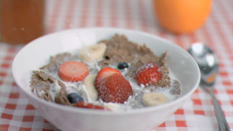 strawberry falling in super slow motion in cereal bowl