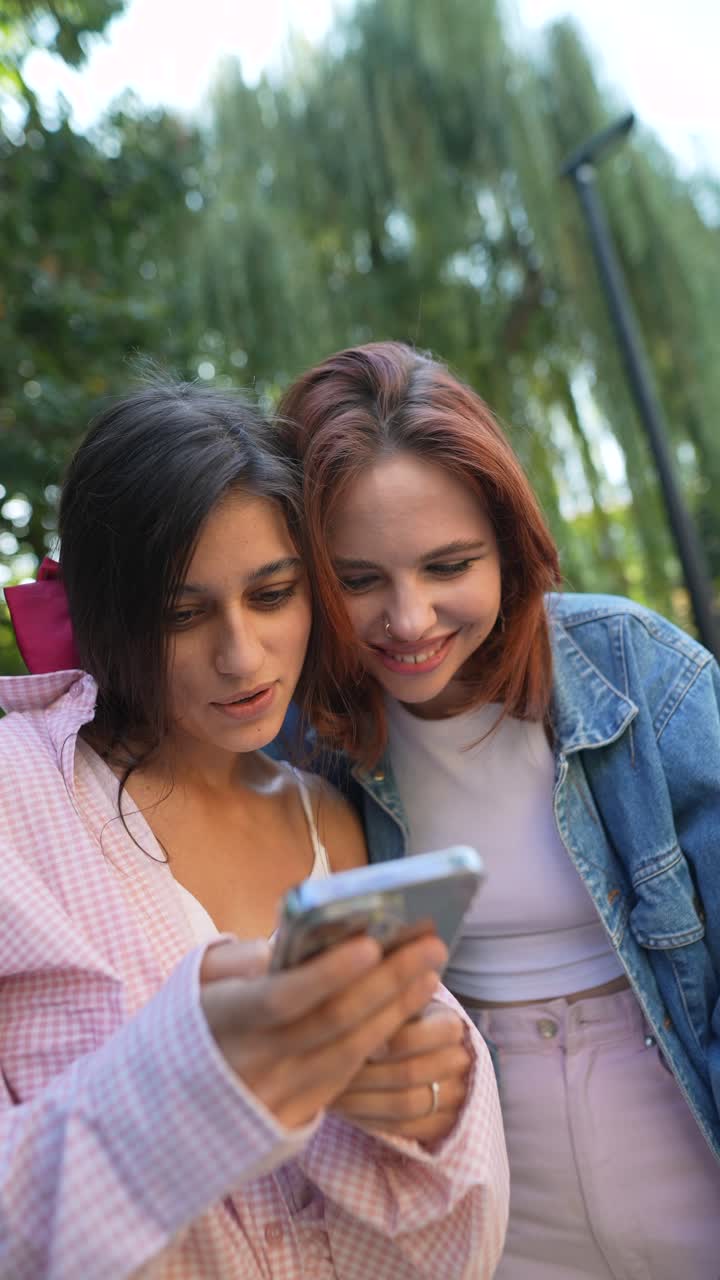 dos mujeres jóvenes mirando un teléfono
