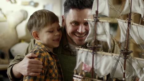 padre e hijo mirando el modelo de barco terminado