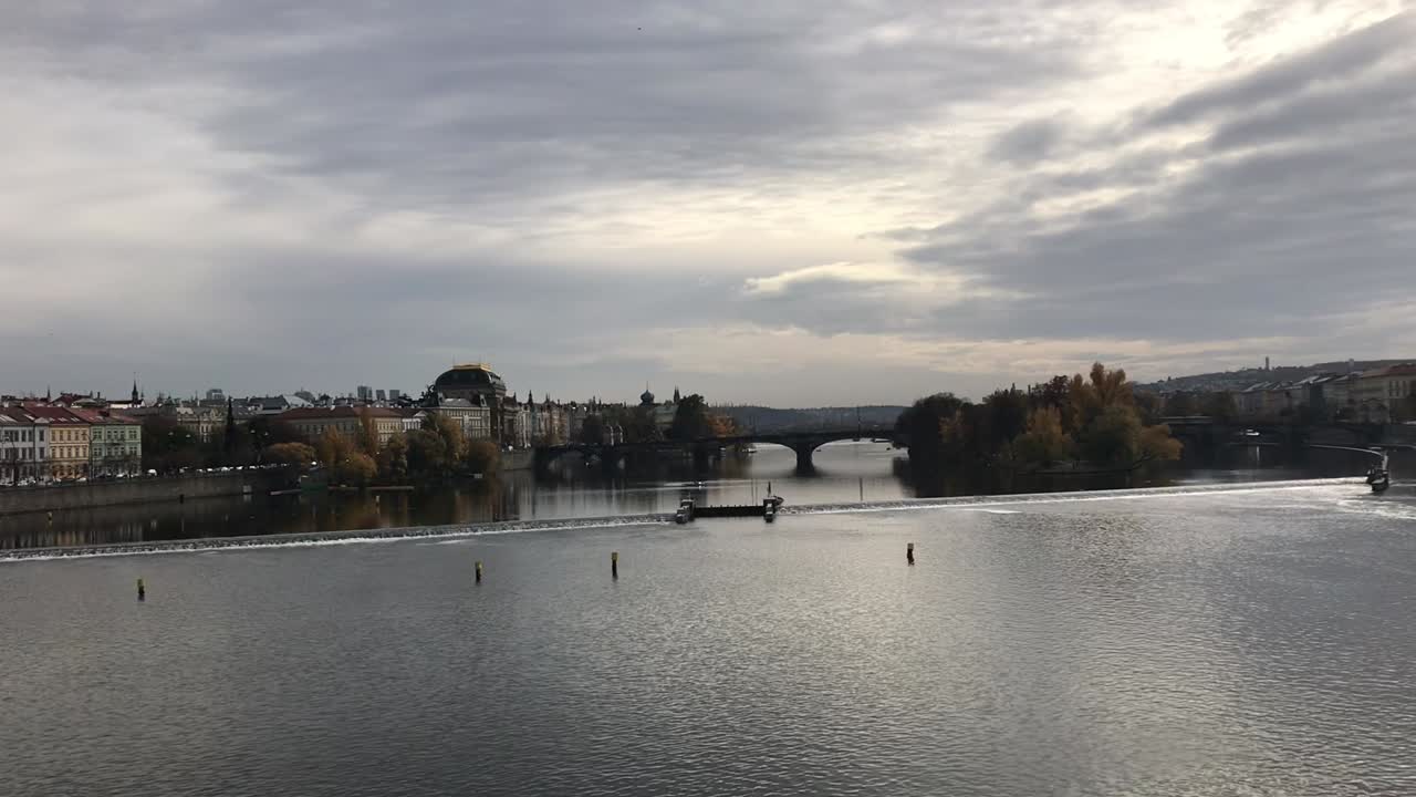 Scenico fiume Moldava a Praga con vista sulla diga, parchi lontani e strade del centro, con un bellissimo paesaggio nuvoloso