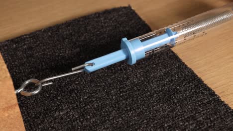 A spring scale measures friction force as a block is dragged across a carpeted surface. Close-up view highlights the interaction