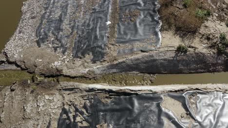 Toma-Aérea-De-Una-Laguna-De-Estiércol-Sobre-Un-Pico-De-Flujo-Que-Drena-Hacia-La-Siguiente-Celda