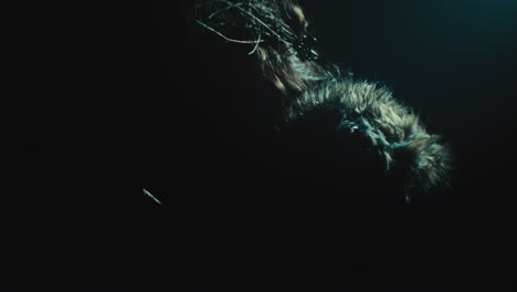 a creepy witch stands in the moody pose during the night storm