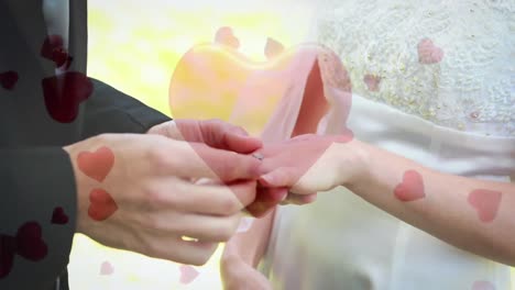 man putting the ring his fiancee with digital hearts