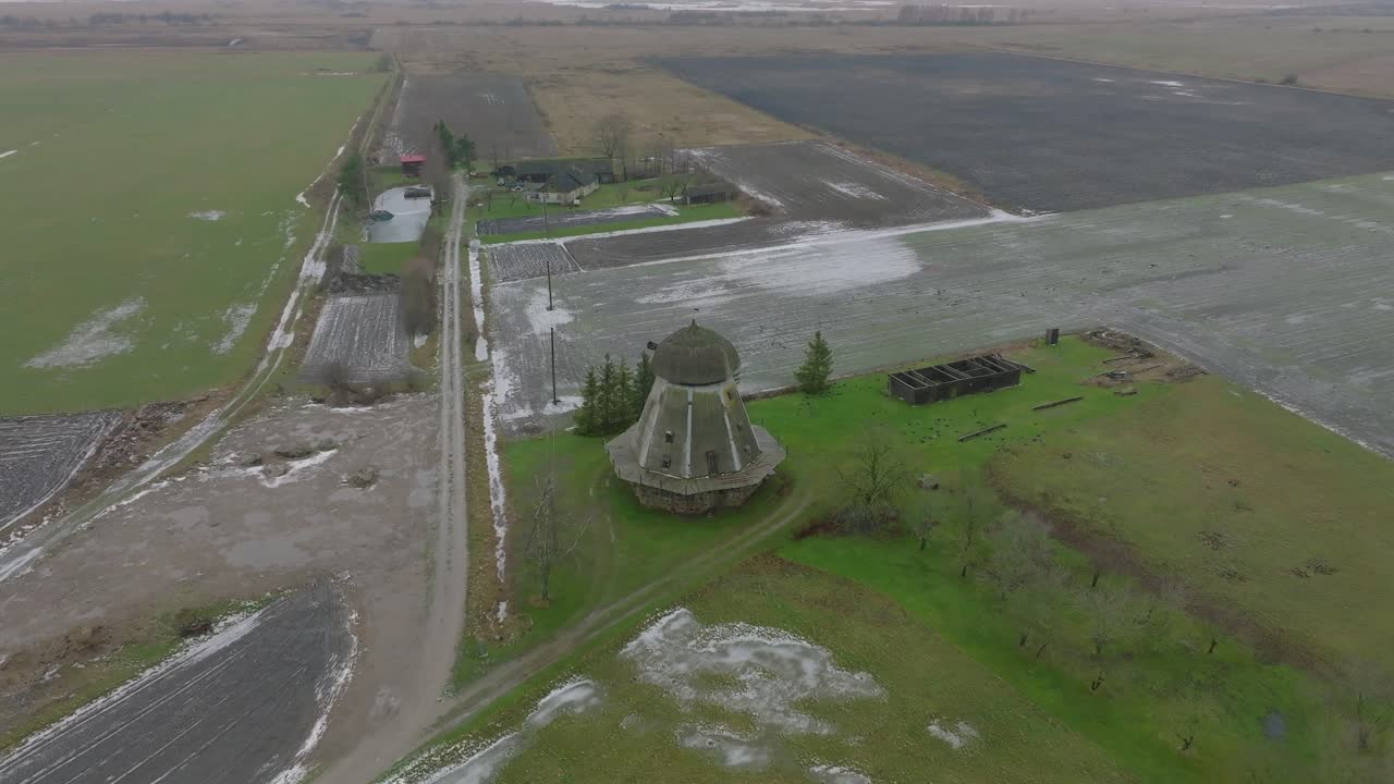 красивый вид с воздуха на старую деревянную ветряную мельницу посреди поля, ветряная мельница в пренклаву, пасмурный зимний день, широкая съемка с дрона, движение вперед, наклон вниз