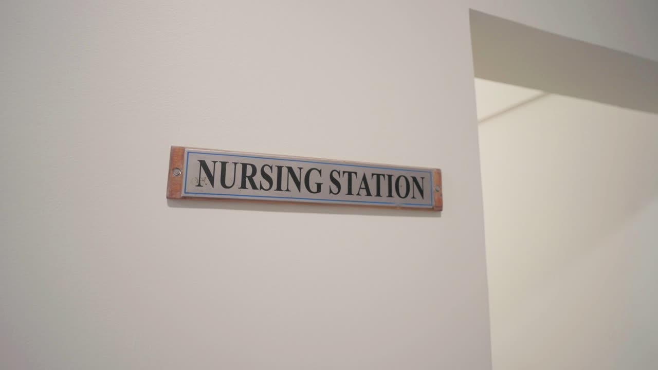 A clear nursing station sign mounted on a white wall in a healthcare setting.