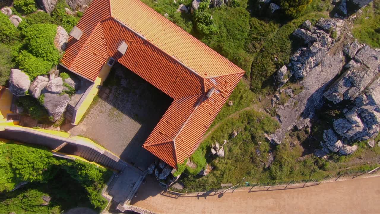 vista aérea sobre la casa de peregrinos de la capilla capela de nossa senhora da peninha, en sintra, portugal - órbita, disparo de drones