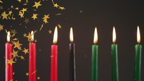 animation of golden stars falling over kwanzaa candles on black background