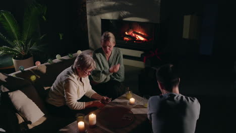 family playing cards by the fireplace