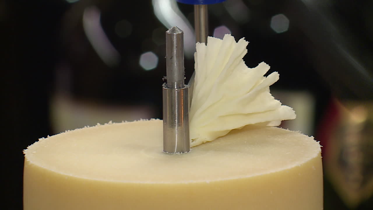 Cheese being sliced by a machine