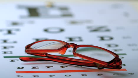 Gafas-De-Lectura-Cayendo-Sobre-La-Prueba-De-La-Vista