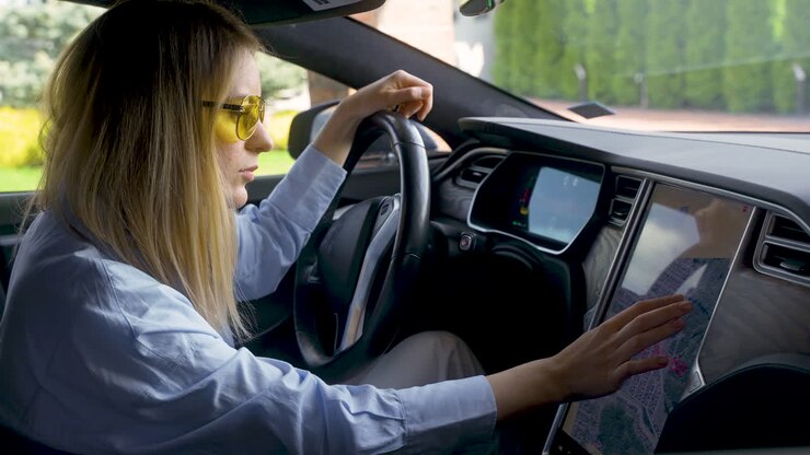Donna bionda seduta su un'auto elettrica
