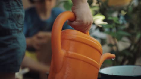 child drains water from the watering can