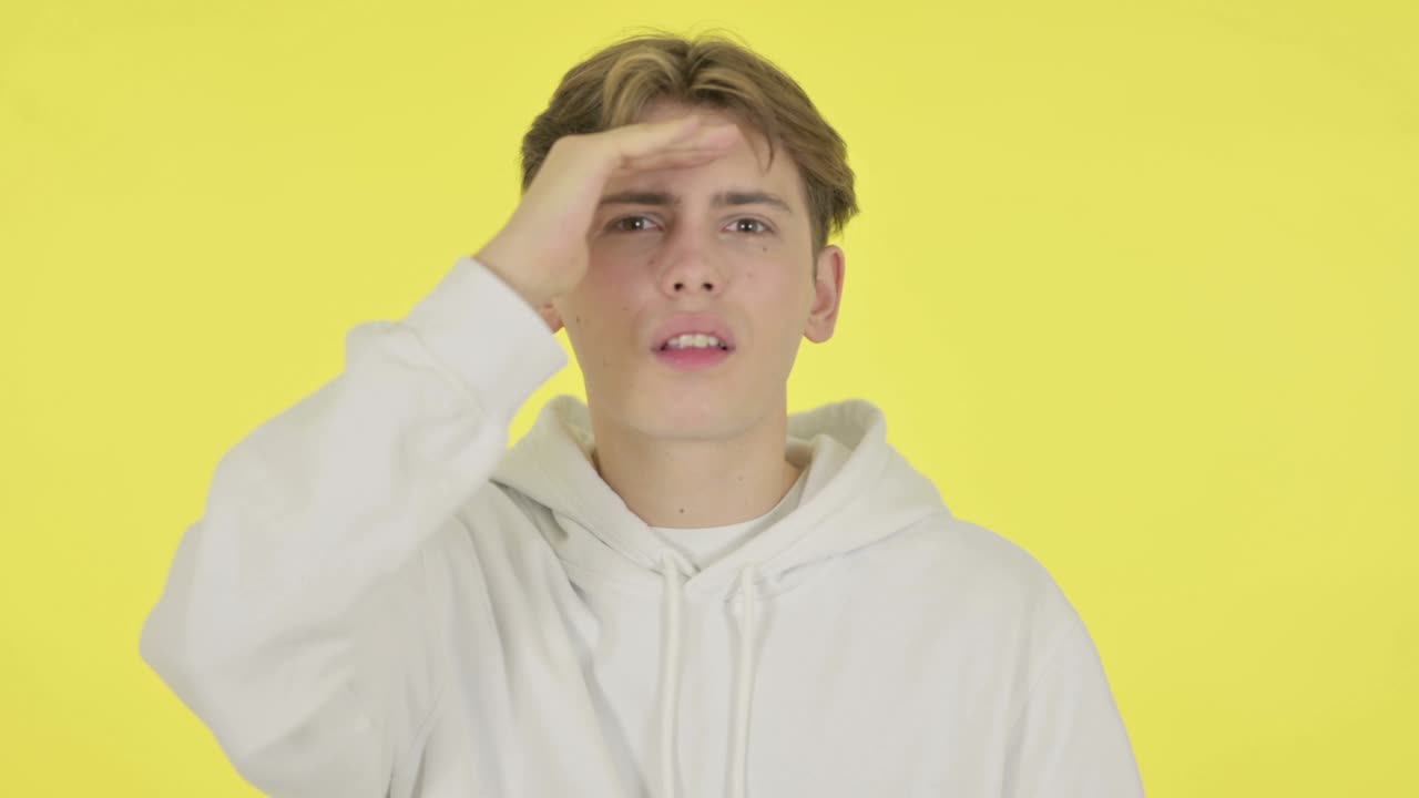 젊은이가 주위를 둘러보고, 노란색 화면을 검색하고