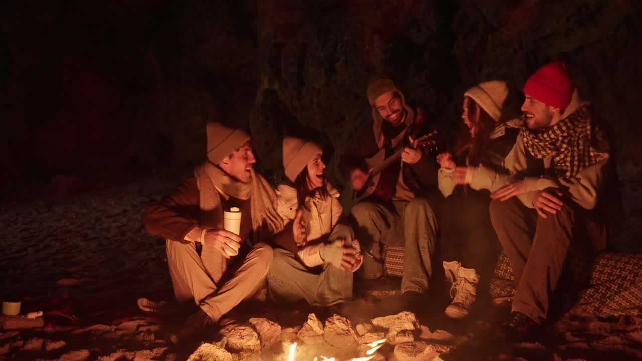 Friends Singing Around a Campfire at Night
