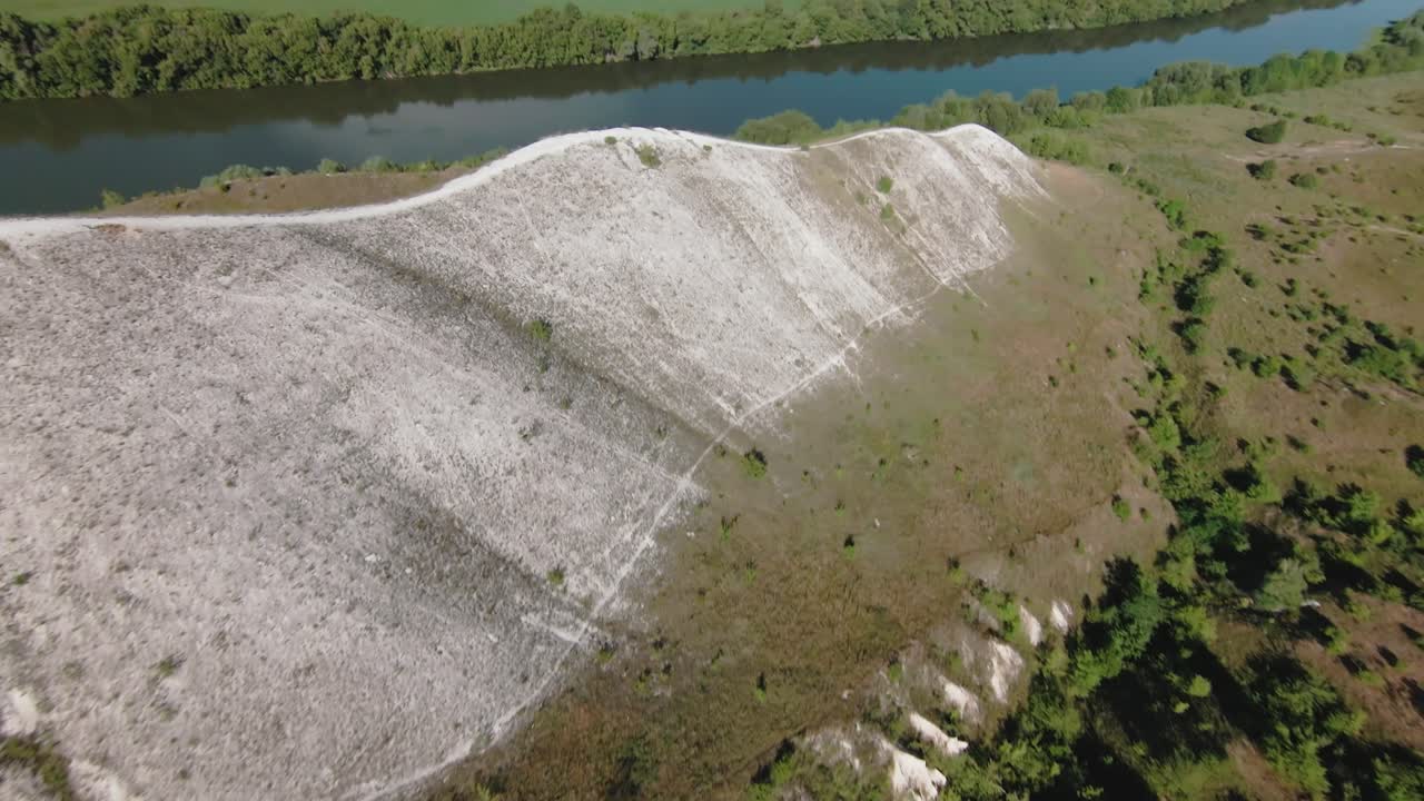 vista aérea de una colina con formaciones rocosas blancas y un bosque