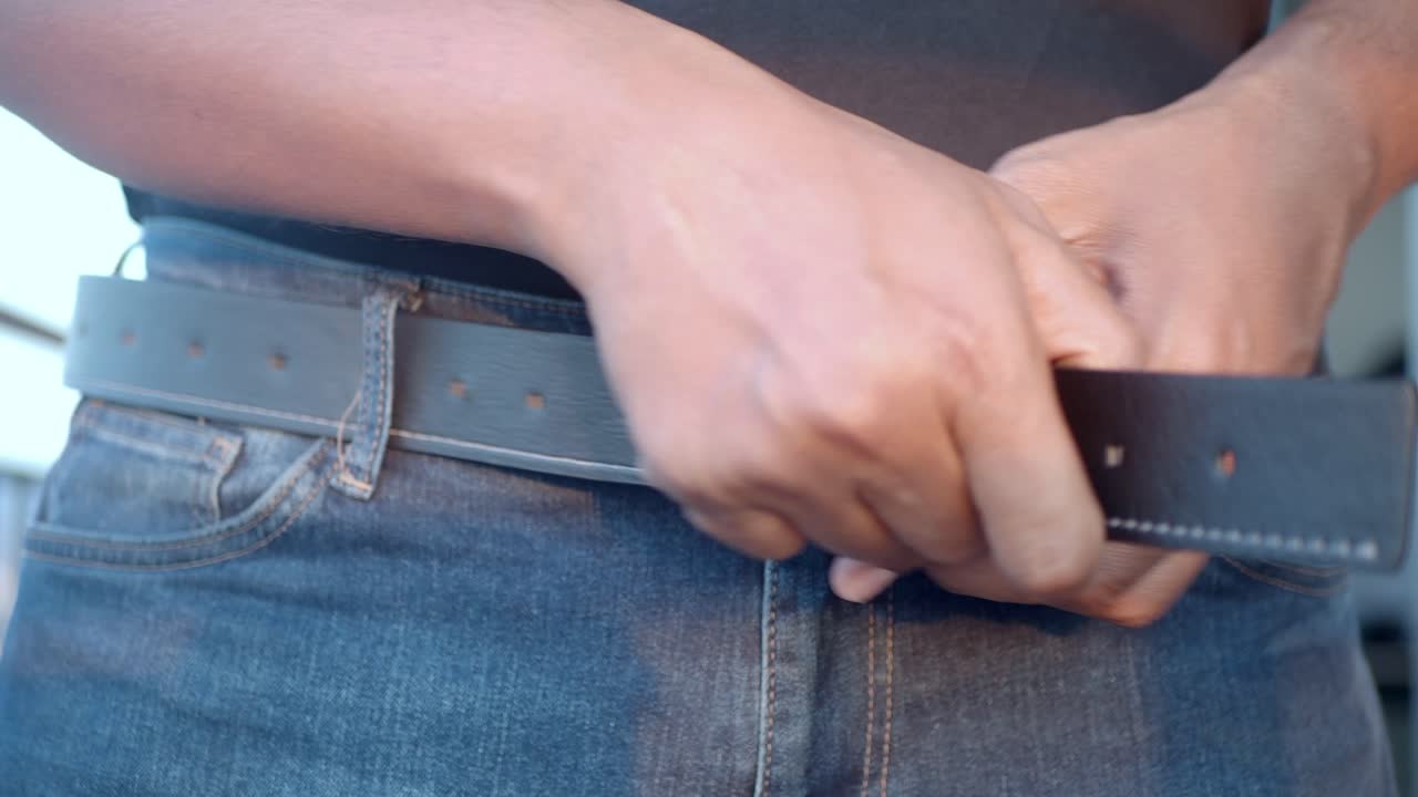 Man Adjusting a Leather Belt