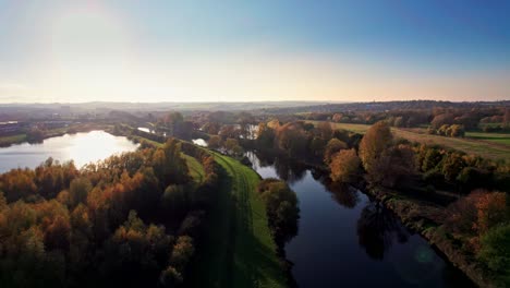 Noch-Fließender-Fluss-Mit-Spiegelnder-Himmelsreflexion,-Kleinem-See,-Grasweg,-Gehweg-Und-Bäumen