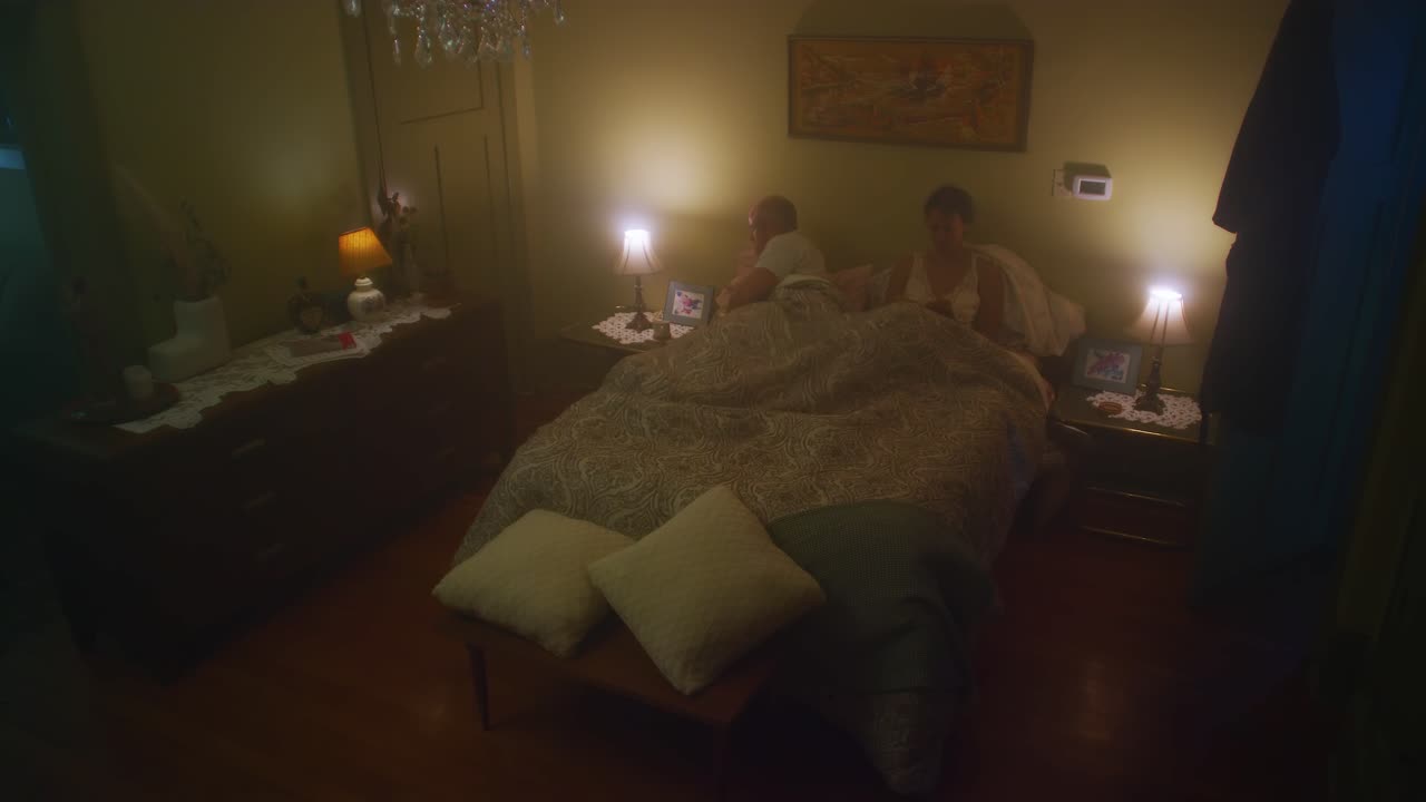 el hombre se mete en la cama con la mujer.